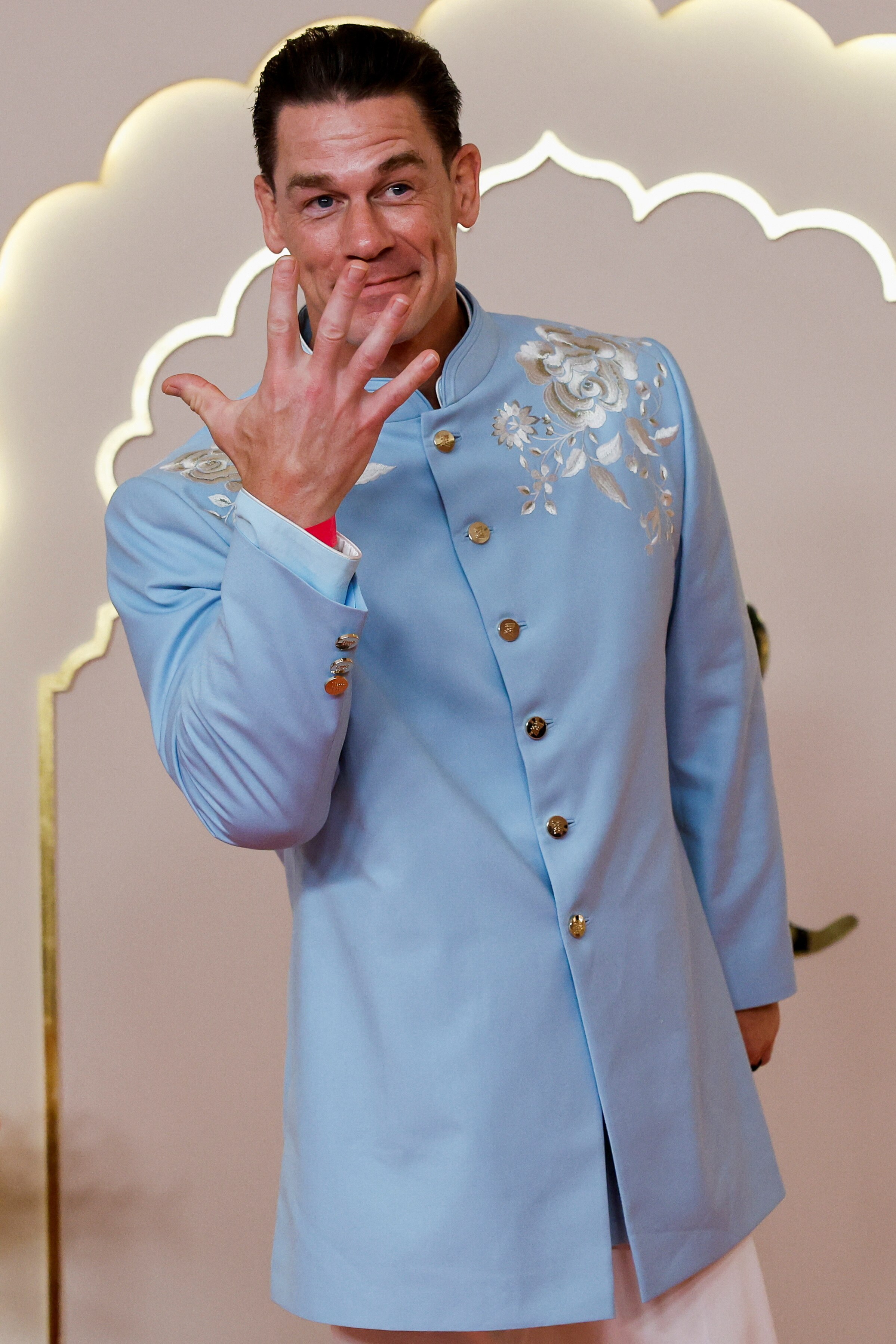 John Cena wearing a pale blue tunic over white pants