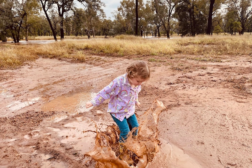 girl plays in puddle