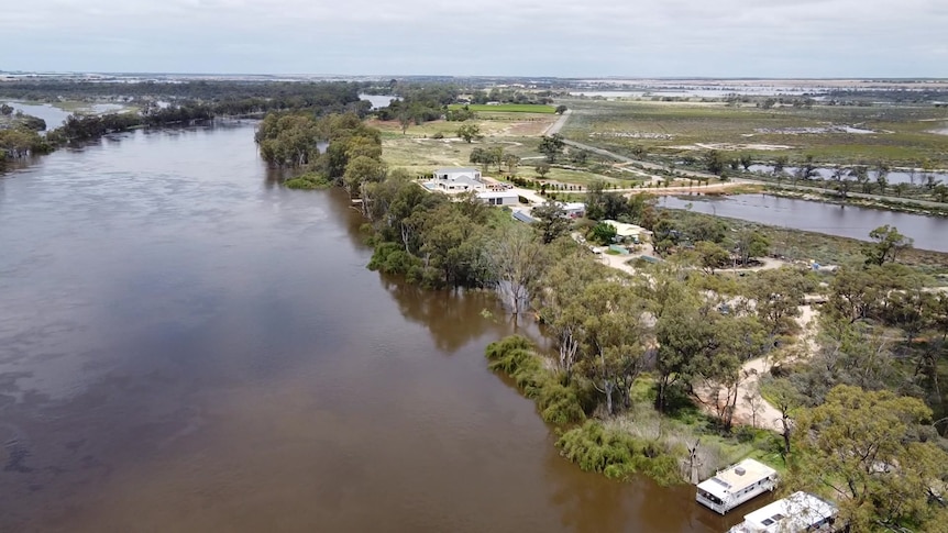 A large river from the air with houses and houseboats next to it