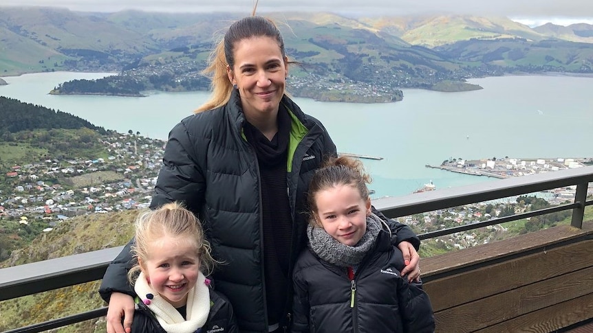 Shona standing at a lookout with her two young daughters.