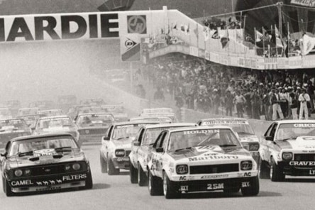 A collection of cars starting a race in black and white