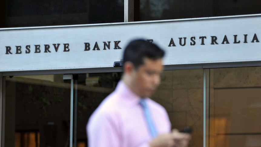 Man walks past Reserve Bank building in Sydney