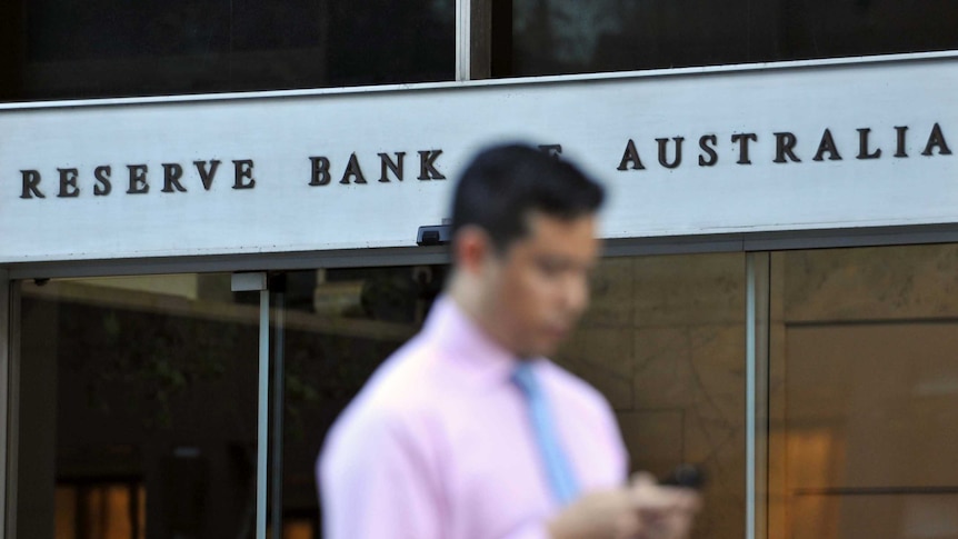 Man walks past Reserve Bank headquarters