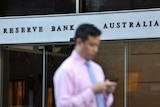 Man walks past Reserve Bank building in Sydney