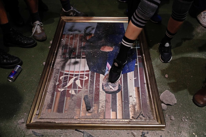 A damaged portrait of former legislative leader lie on the ground after protesters broke into the Legislative Council building