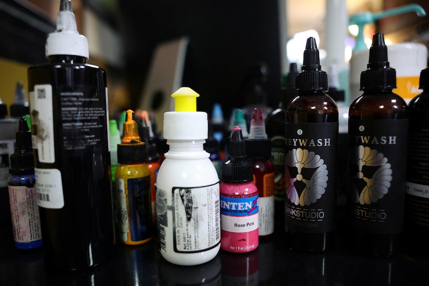 A close up of bottles of tattoo ink in a tattoo studio. 