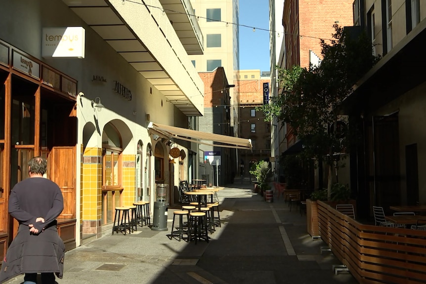 A small pedestrianised street with only one person walking in it