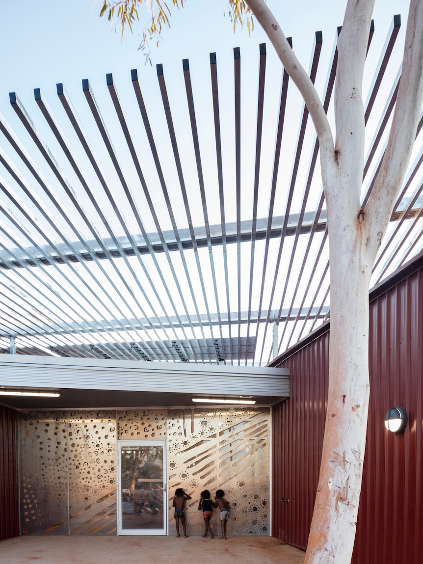 Children peer into a modern new building