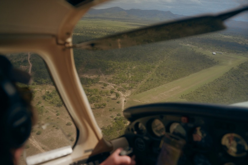 Man flies small plane looking out over rural country