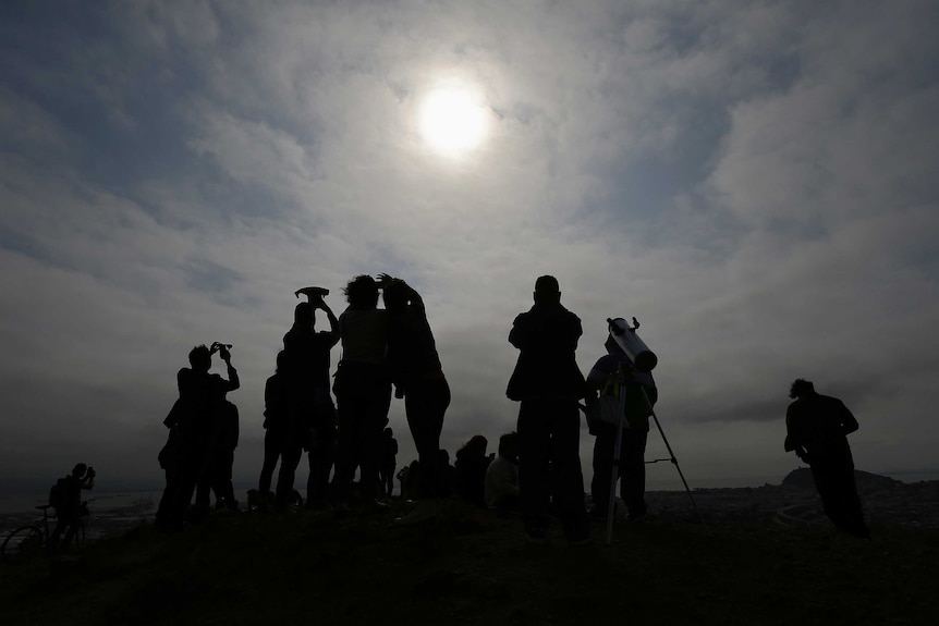 A crowd watches the total solar eclipse from Bernal Heights Hill in San Francisco.