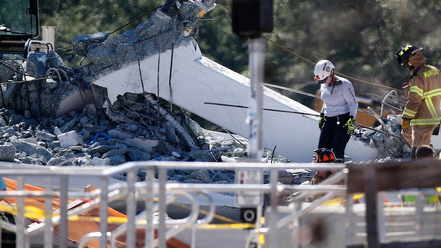 Rescue workers search rubble after a bridge collapsed at Florida International University