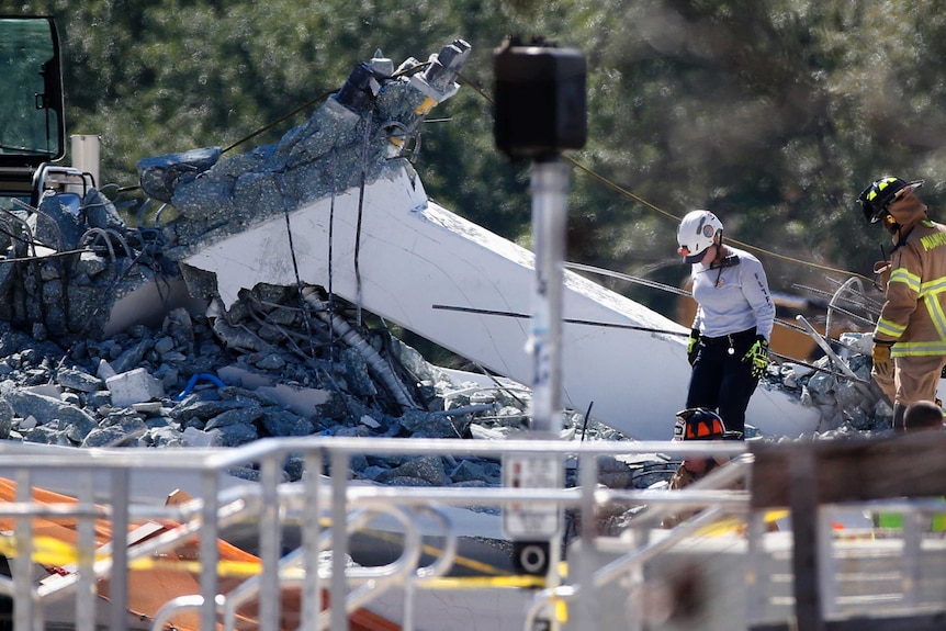 Rescue workers search rubble after a bridge collapsed at Florida International University