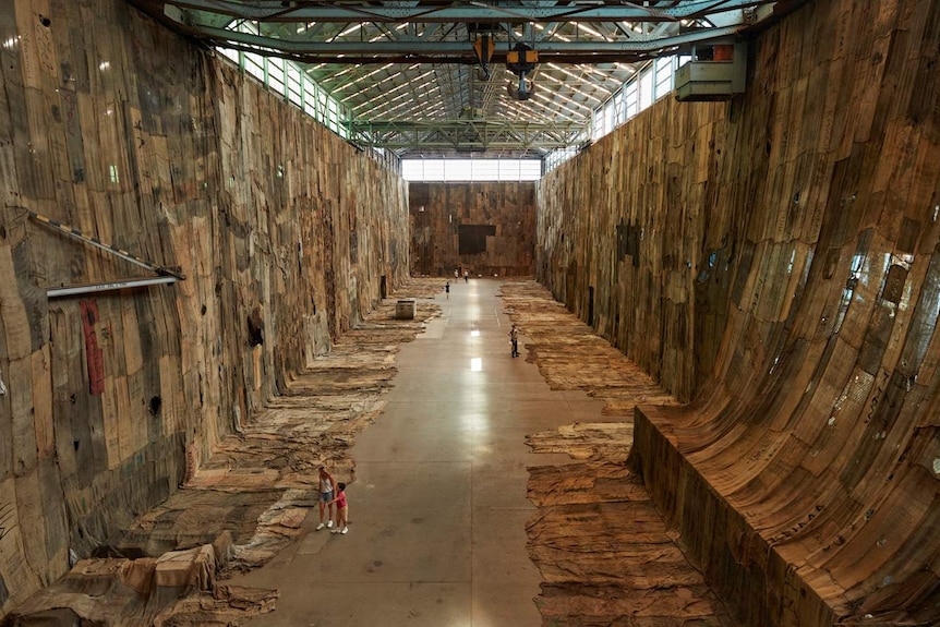 Large turbine hall with concrete floor and walls lined with hessian sacks.