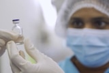 Worker looks at AstraZeneca vaccine