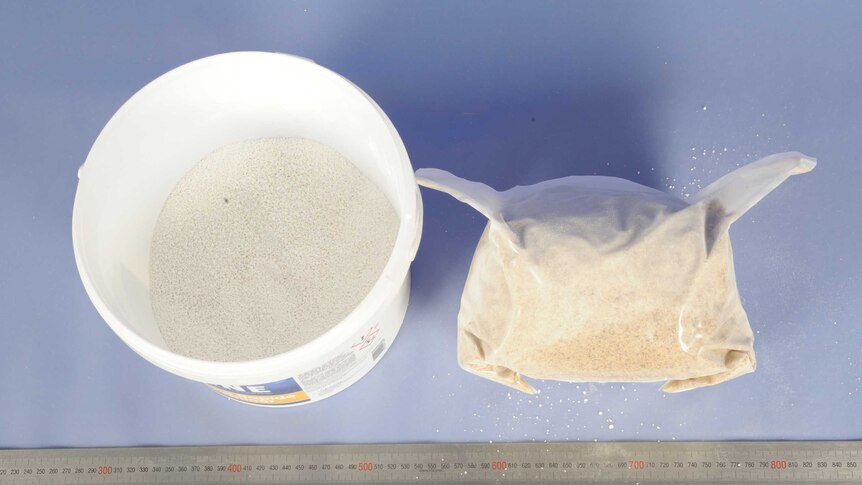 A bucket with white powder inside and a bag of MDMA.