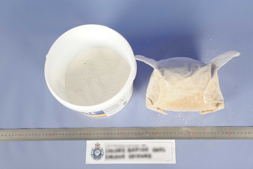 A bucket with white powder inside and a bag of MDMA.