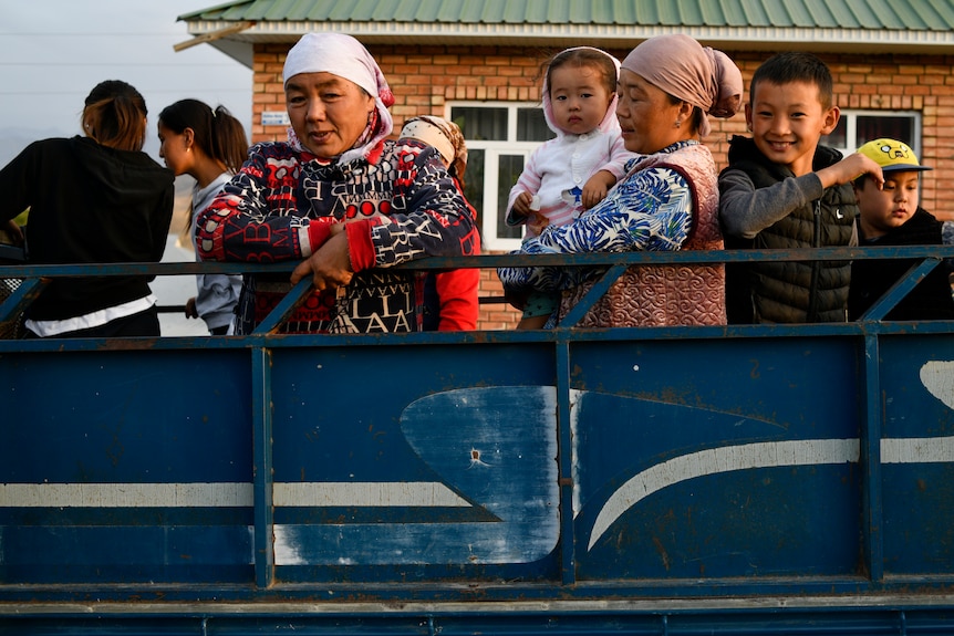 Kyrgyzstan's displaced families stand in the back of a truck.