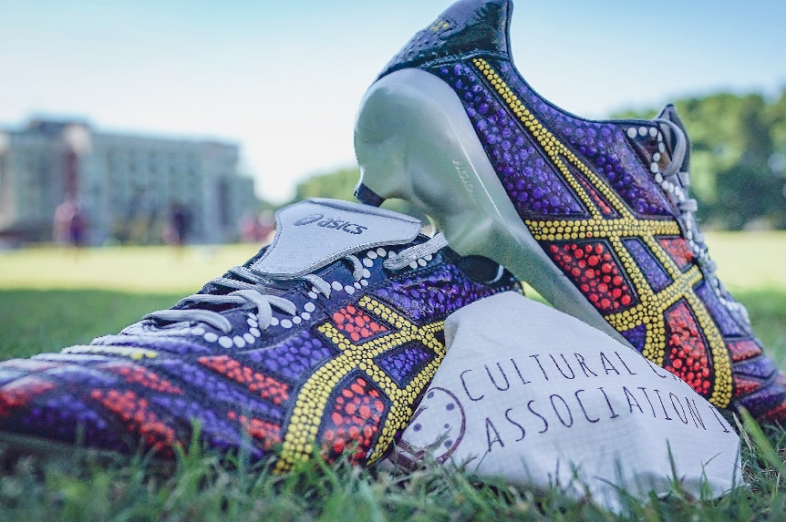 Football boots painted in colourful Indigenous art