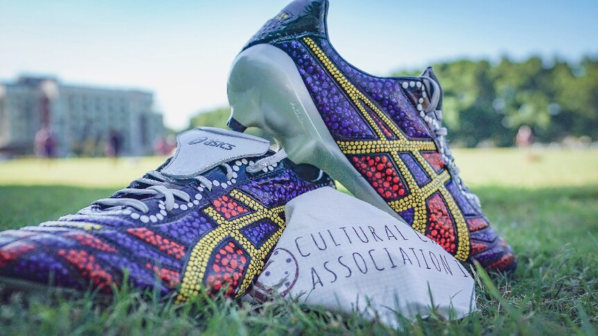 Football boots painted in colourful Indigenous art
