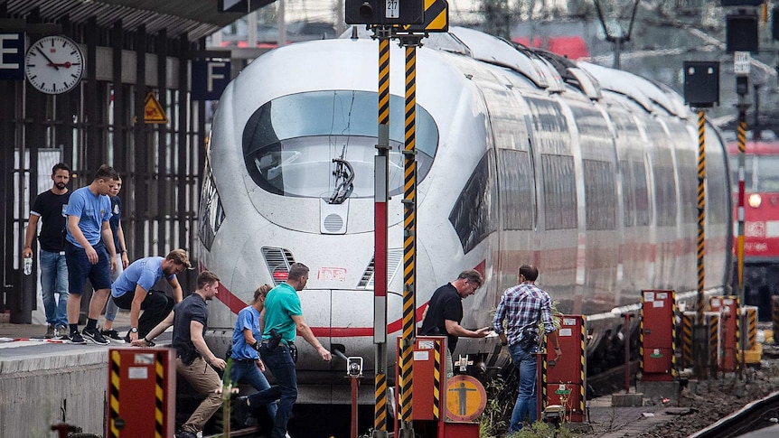 Police officers walks next to an ICE highspeed train at the main station in Frankfurt, after the incident.