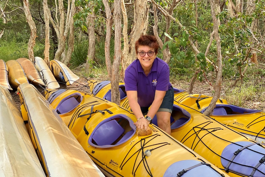 Noosa tourism operator Kym McGregor with kayaks on a beach on March 30, 2021.