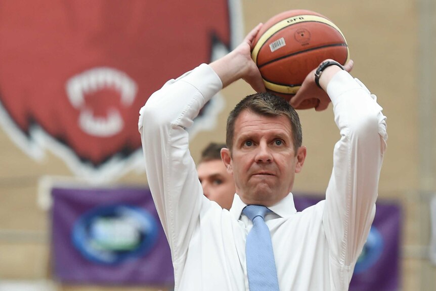 NSW Premier Mike Baird plays a shot as he visits a Queanbeyan basketball centre