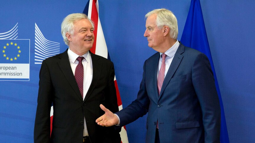 Michel Barnier reaches out to shake hands with British Secretary of State for Exiting the European Union David Davis.