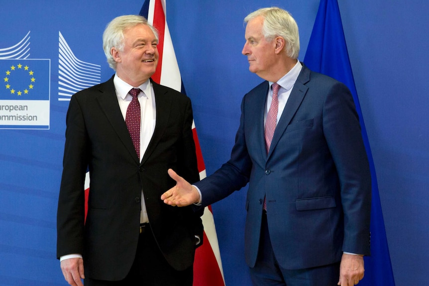 Michel Barnier reaches out to shake hands with British Secretary of State for Exiting the European Union David Davis.