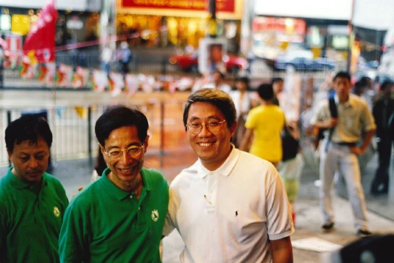 Martin Lee poses for photographs with locals as he campaigns on election day in 1998.