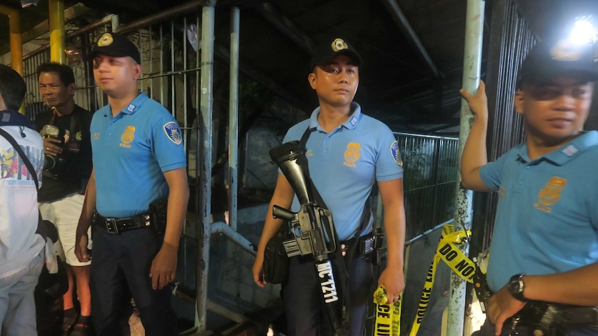 Police secure a crime scene where a drug runner was killed in Marikina City, Philippines