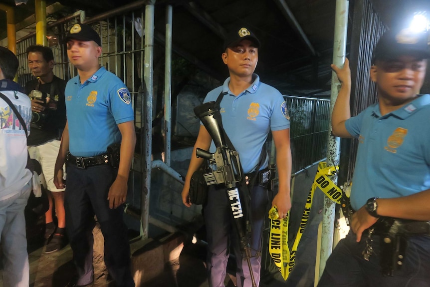 Police secure a crime scene where a drug runner was killed in Marikina City, Philippines