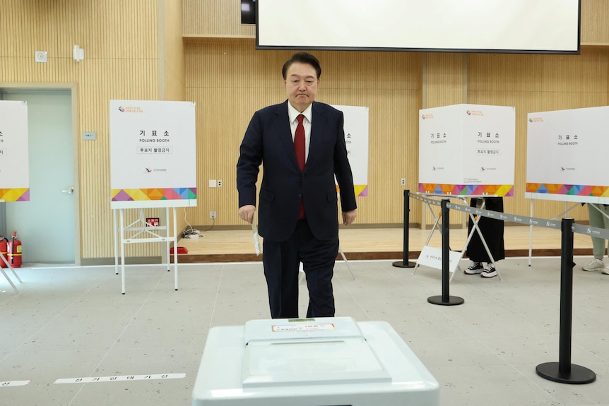 South Korea President walks solo out of a room full of ballot boxes.