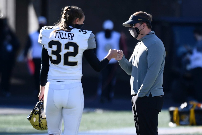 Vanderbilt place kicker Sarah Fuller (32) fist-bumps Missouri head coach Eliah Drinkwitz ahead of their college football game.