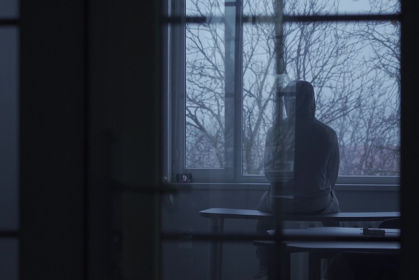 A moody scene of a man in a hoody.