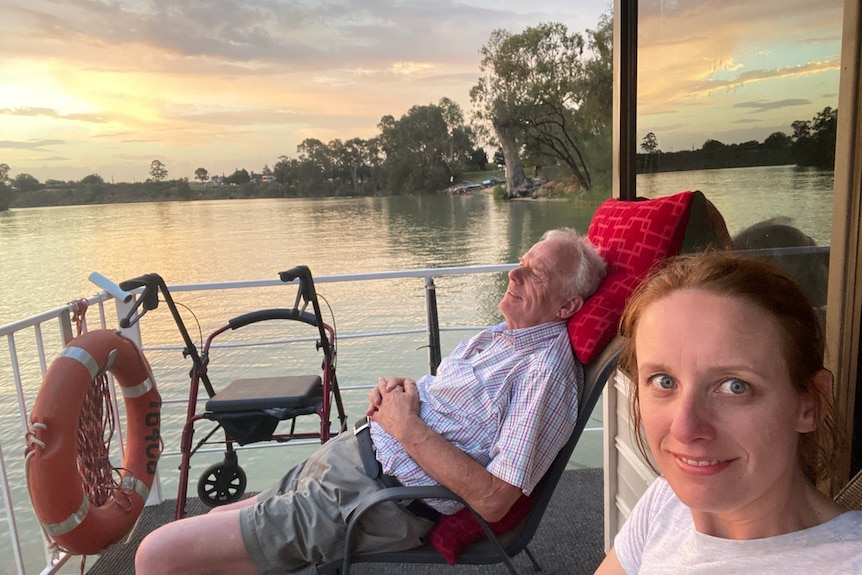 Dr Kristin Cornell with her father, Allan, sitting by a lake with the sun setting.
