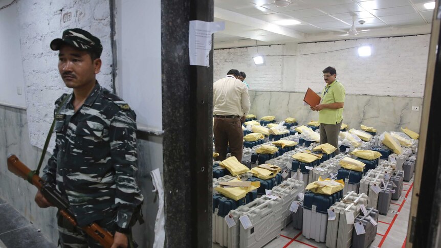 An Indian paramilitary soldier stands guard outside a room where voting machines.