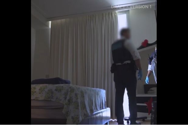 A policeman looks through a bedroom during a search of a property.