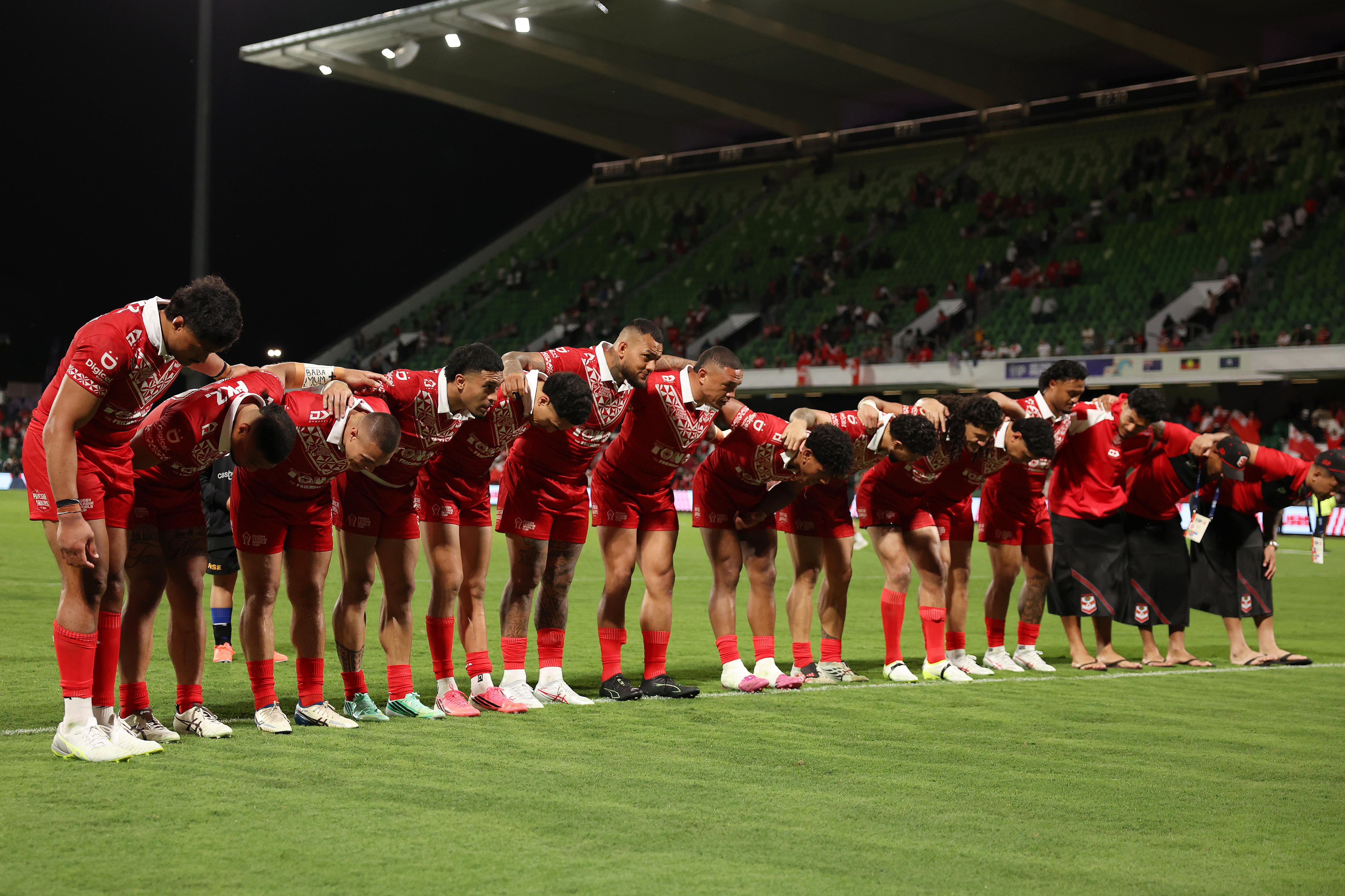 The Tongan men's rugby league team bows to the crowd after a win at the Rugby League World Cup.