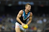 AFL player running the ball during a match