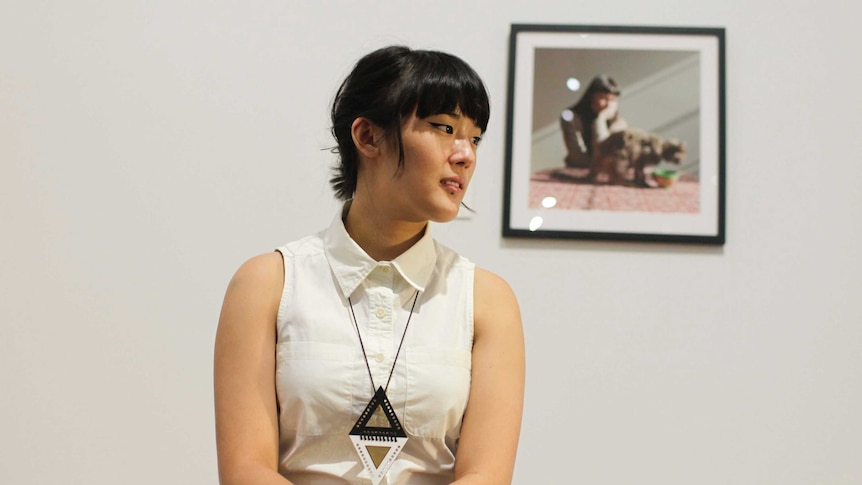 Photographer Janelle Low poses in front of her winning picture 'Yhonnie and Indiana 2012'