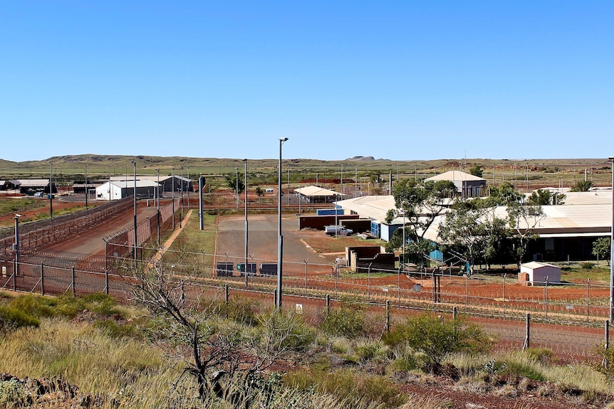 A wide shot looking from a hill into Roebourne prison