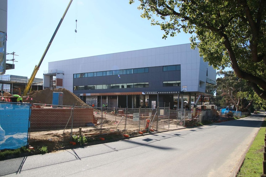 The Bob Hawke College construction site with buildings, temporary fences, materials and a crane.