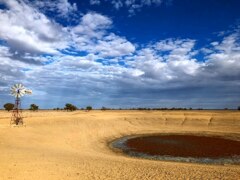 An empty dam with a windmill next to it