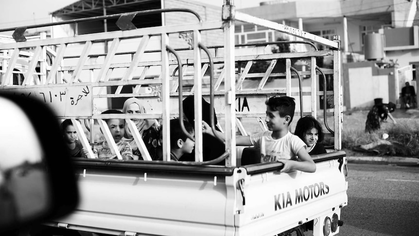 Children sitting in the back of a ute