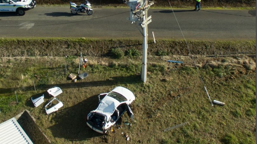 An aerial photo showing car wreckage near a power pole.