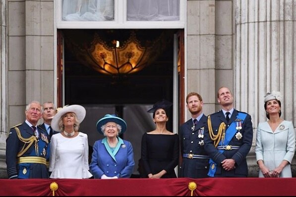 Prince Charles, Camilla, the Queen, Meghan Markle, Prince Harry, Prince William and Duchess Catherine stand on a balcony