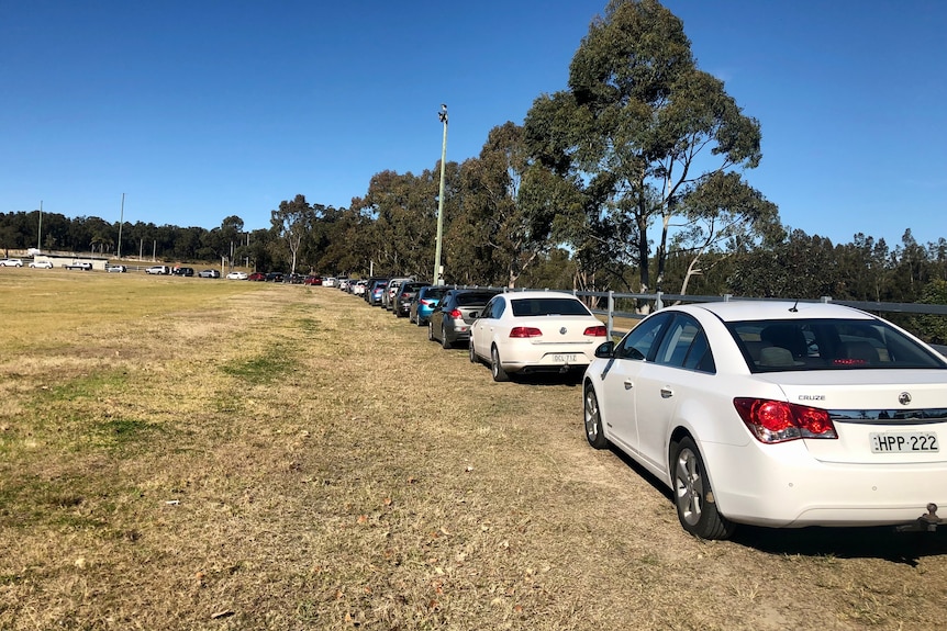 Cars line up at a showground for COVID test.