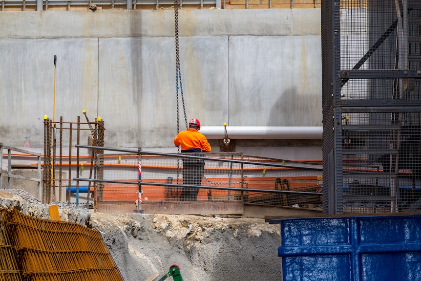 A lone construction worker wearing high-vis.