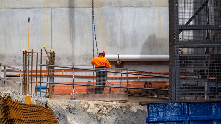 A lone construction worker wearing high-vis.