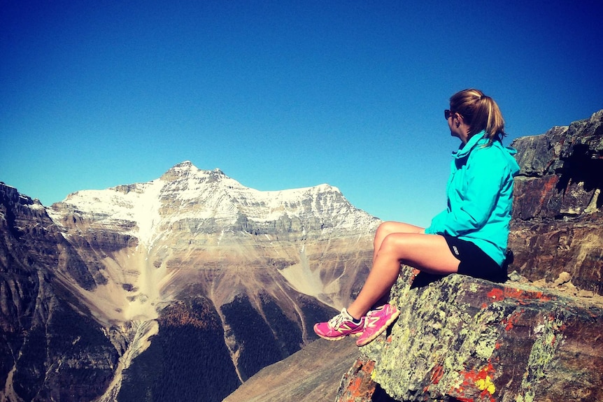 Renea Jaeger sits on the edge of a rock face during her adult gap year